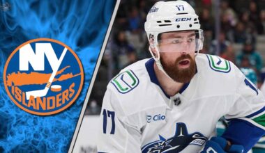 Filip Hronek of the Vancouver Canucks skating with the puck against the New York Islanders defense.