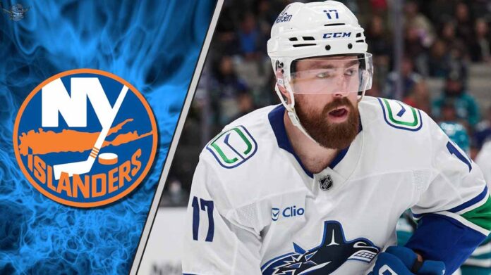 Filip Hronek of the Vancouver Canucks skating with the puck against the New York Islanders defense.