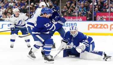 Toronto Maple Leafs goaltender Dennis Hildeby (35) makes a save in front of Tampa Bay Lightning's Jake Guentzel (59) and Leafs defenseman Jake McCabe (22) during the first period of an NHL hockey game in Toronto, Monday, Dec. 8, 2025. (Chris Young/The Canadian Press via AP)