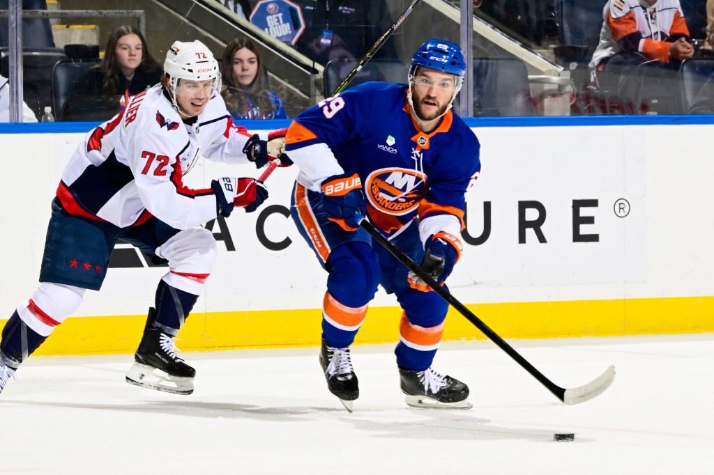 Jonathan Drouin playing the puck against Anthony Beauvillier during an ice hockey game.