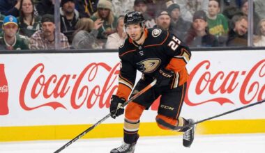 A hockey player, Jordan Kyrou, wearing the black Anaheim Ducks uniform with number 25, is skating with the puck on the ice during a game.