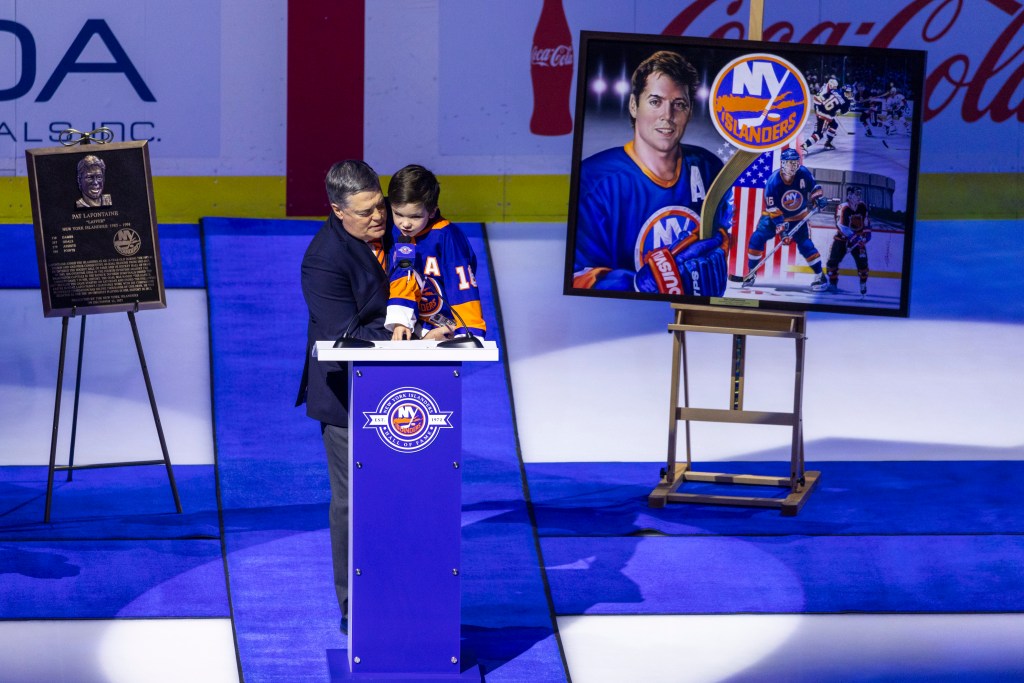 Pat LaFontaine and a child speaking at a podium during his New York Islanders Hall of Fame induction ceremony.