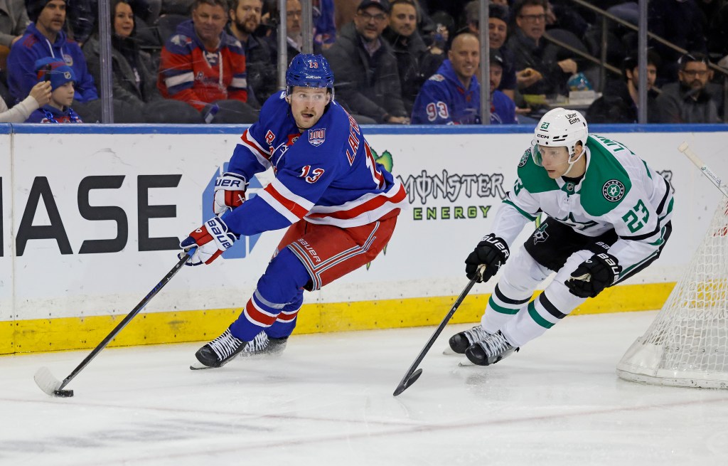 New York Rangers' Alexis Lafrenière with the puck followed by Dallas Stars' Esa Lindell.