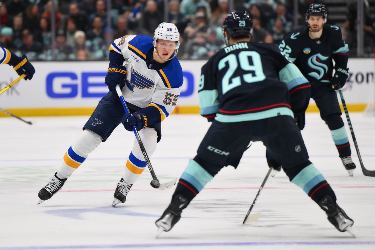 St. Louis Blues center Nikita Alexandrov (59) plays the puck while defended by Seattle Kraken defenseman Vince Dunn (29) during the third period at Climate Pledge Arena. 
