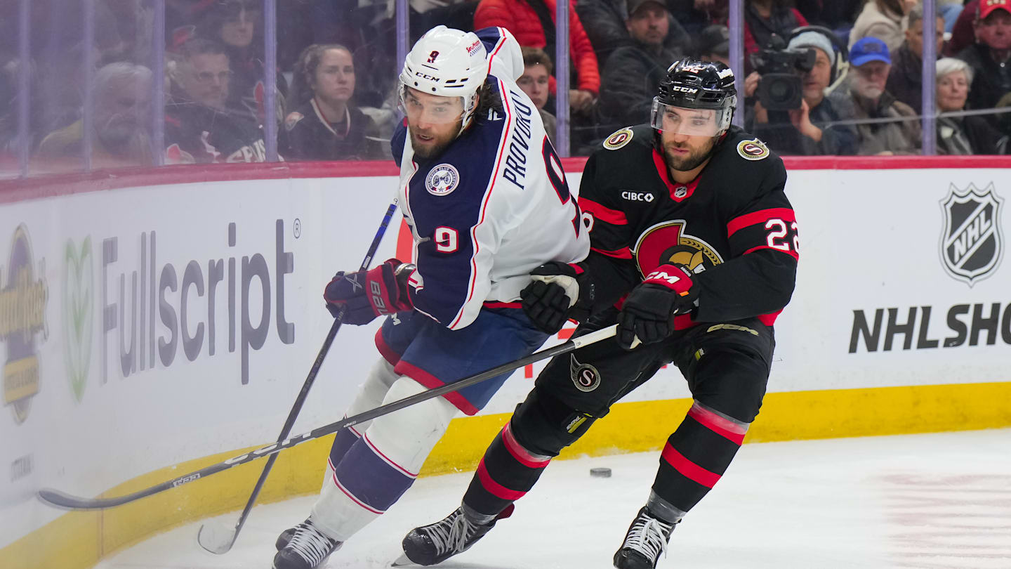 Blue Jackets defenseman Ivan Provorov shoots the puck away from Senators forward Michael Amadio.