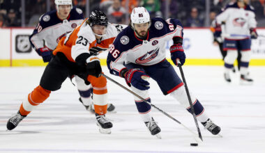 Blue Jackets forward Kirill Marchenko shields the puck from a Flyers back-checker.
