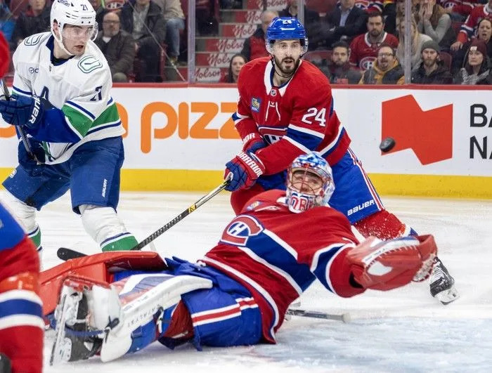  Montreal Canadiens goalie Jakub Dobes and teammate Phillip Danault watch with Vancouver Canucks’ Nils Hoglander as Evander Kane’s shot heads to Montreal’s net for a goal during the second period at the Bell Centre in Montreal on Monday January 12, 2026.