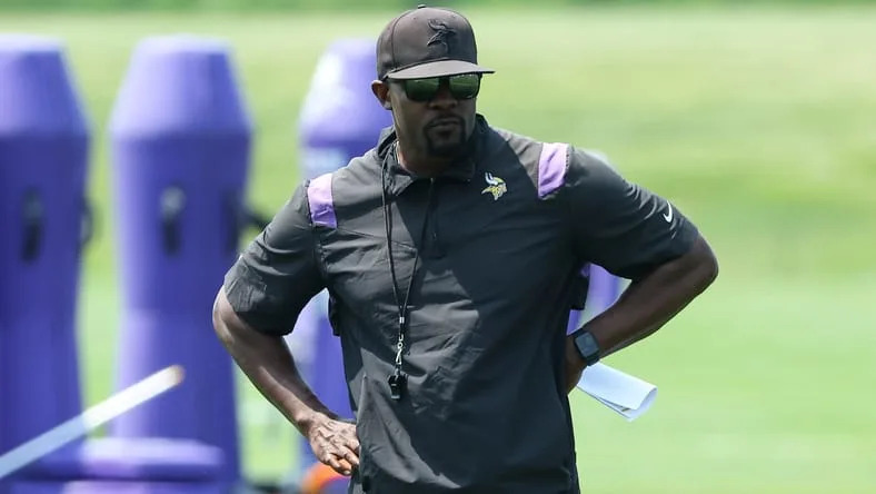 Brian Flores observes Vikings defensive drills during minicamp.
