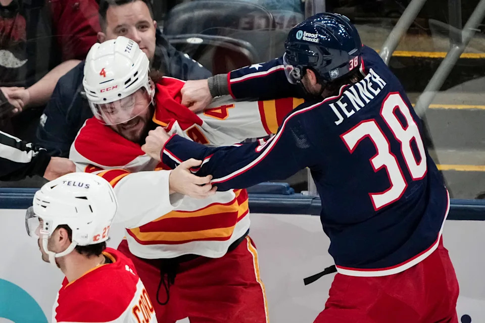 Blue Jackets center Boone Jenner fights Flames defenseman Rasmus Andersson.
