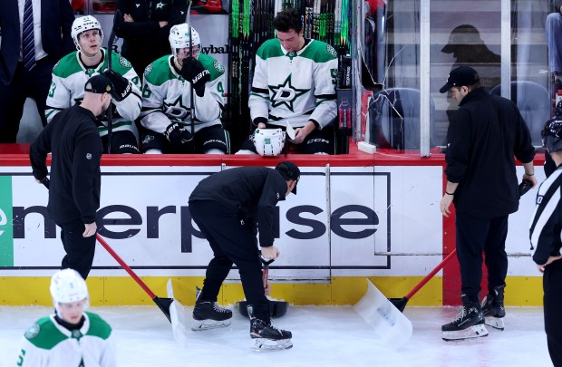Broken glass is is cleaned up from in front of the Dallas Stars bench in the second period of a game between the Stars and the Chicago Blackhawks at the United Center in Chicago on Jan. 1, 2026. (Chris Sweda/Chicago Tribune)