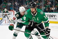 Dallas Stars left wing Jamie Benn (14) handles the puck near the boards as Minnesota Wild...