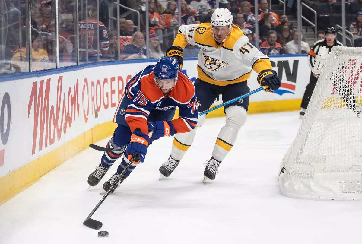 Nashville Predators' Michael McCarron (47) and Edmonton Oilers' Alec Regula (75) battle for the puck during second period NHL action, in Edmonton, Alberta, on Tuesday, Jan. 6, 2026. THE CANADIAN PRESS/Jason Franson/The Canadian Press via AP)