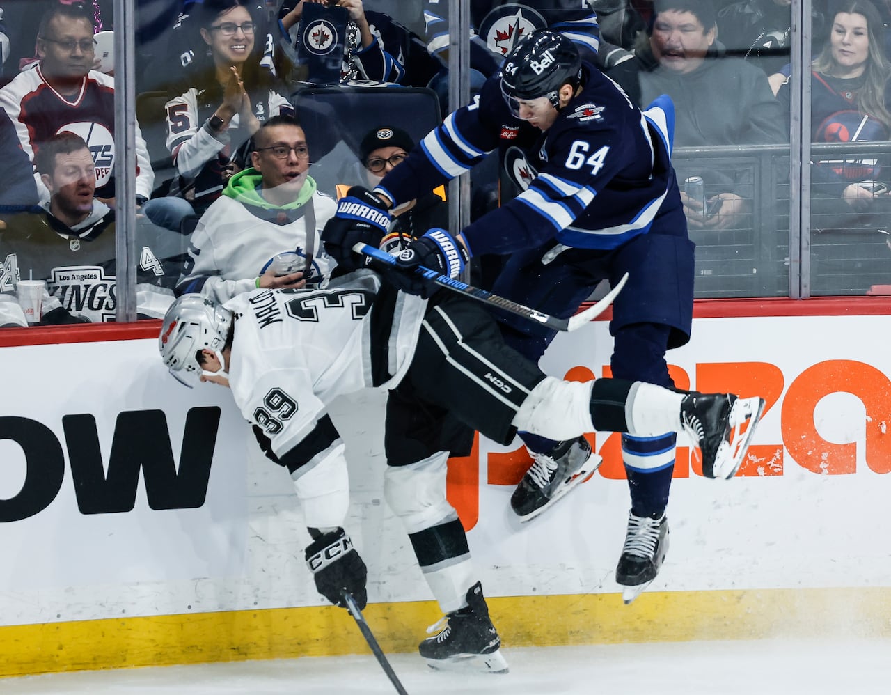 Two hockey players collide along the boards.