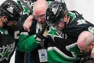 Dallas Stars defenseman Lian Bichsel (6) is helped from the ice by head team physician Dr....