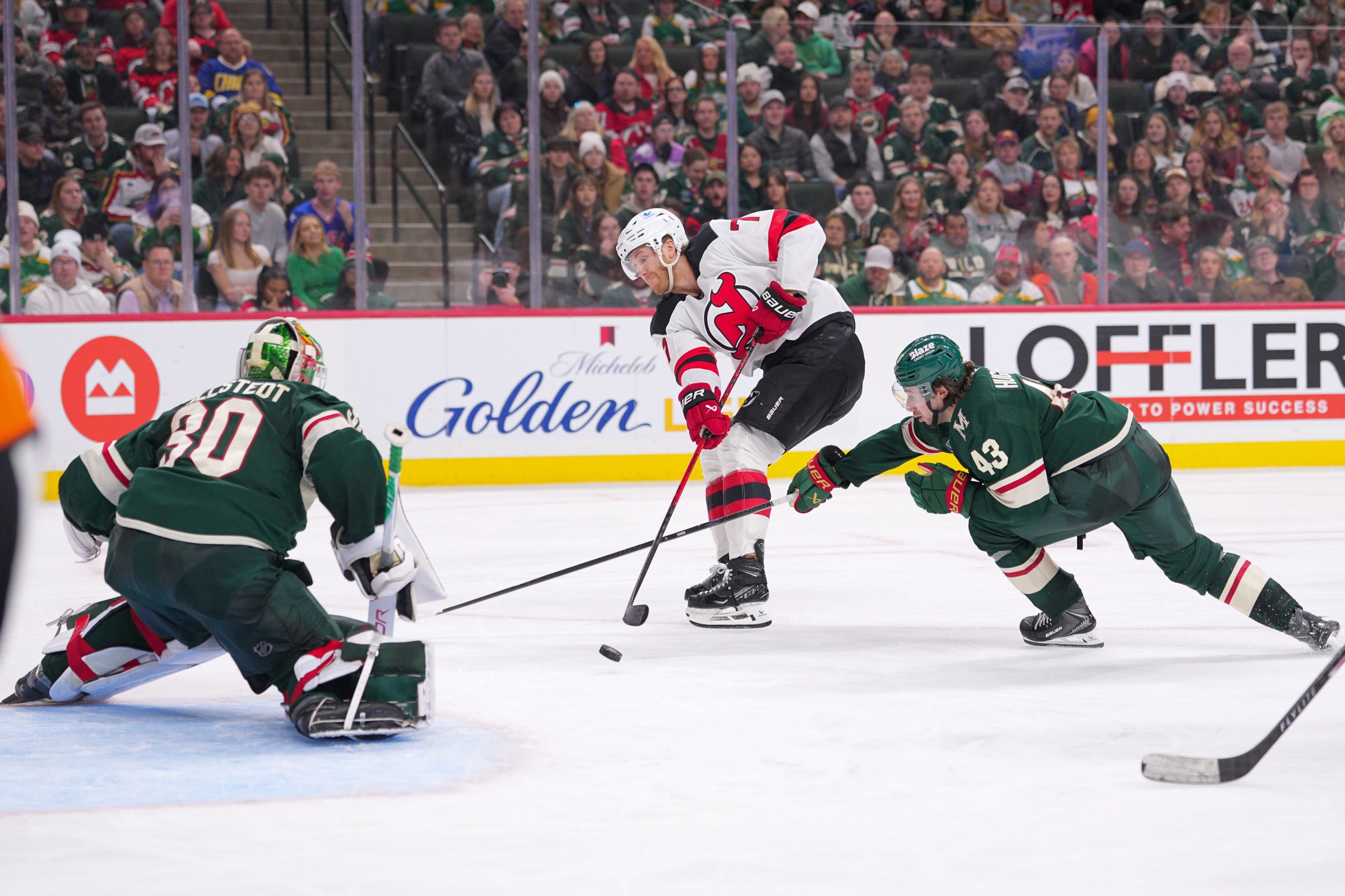 ST PAUL, MINNESOTA - JANUARY 12: Dougie Hamilton #7 of the New Jersey Devils passes to Jesper Bratt #63 (not pictured) for a goal against Quinn Hughes #43 of the Minnesota Wild in the third period at Grand Casino Arena on January 12, 2026 in St Paul, Minnesota. (Photo by Brad Rempel/Getty Images)