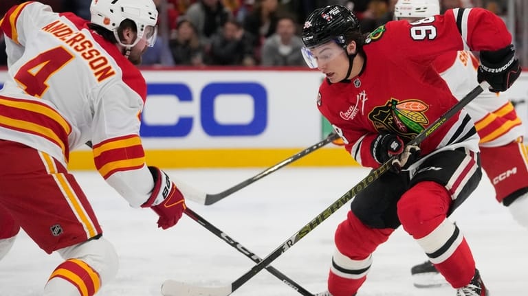 Calgary Flames defenseman Rasmus Andersson (4) checks Chicago Blackhawks center...
