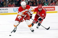 Calgary Flames' Rasmus Andersson (4) drives the puck around Carolina Hurricanes' Jordan...