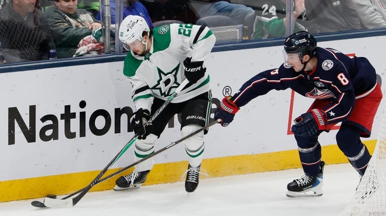 Dallas Stars' Mavrik Bourque, left, controls the puck as Columbus...