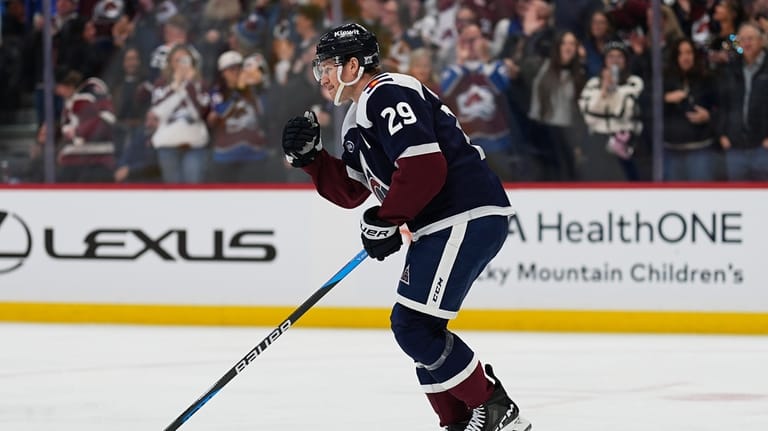Colorado Avalanche center Nathan MacKinnon celebrates as he skates back...
