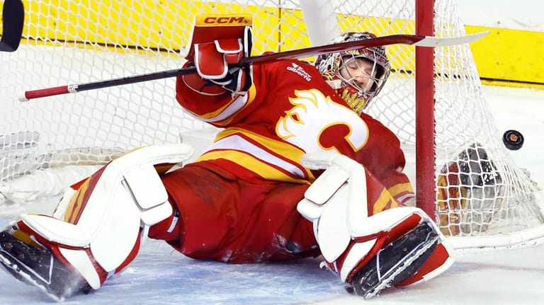 Calgary Flames goalie Dustin Wolf makes a save against the...