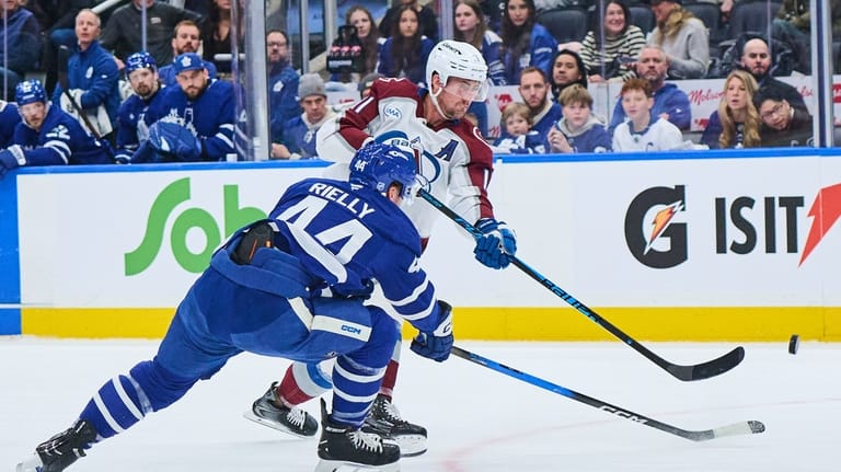 Colorado Avalanche's Brock Nelson (11) shoots past Toronto Maple Leafs'...