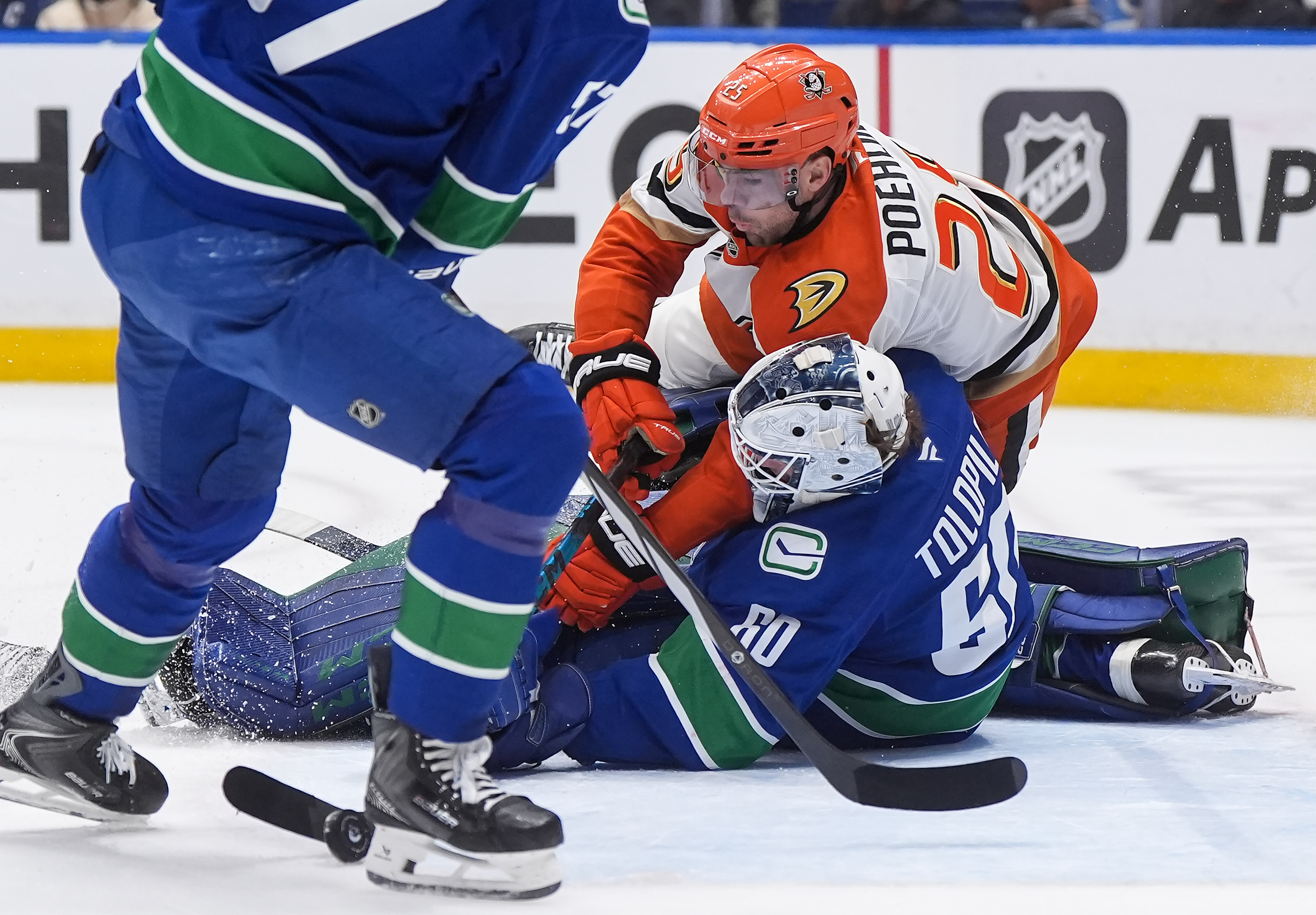 The Ducks’ Ryan Poehling (25) crashes into Vancouver Canucks goalie...