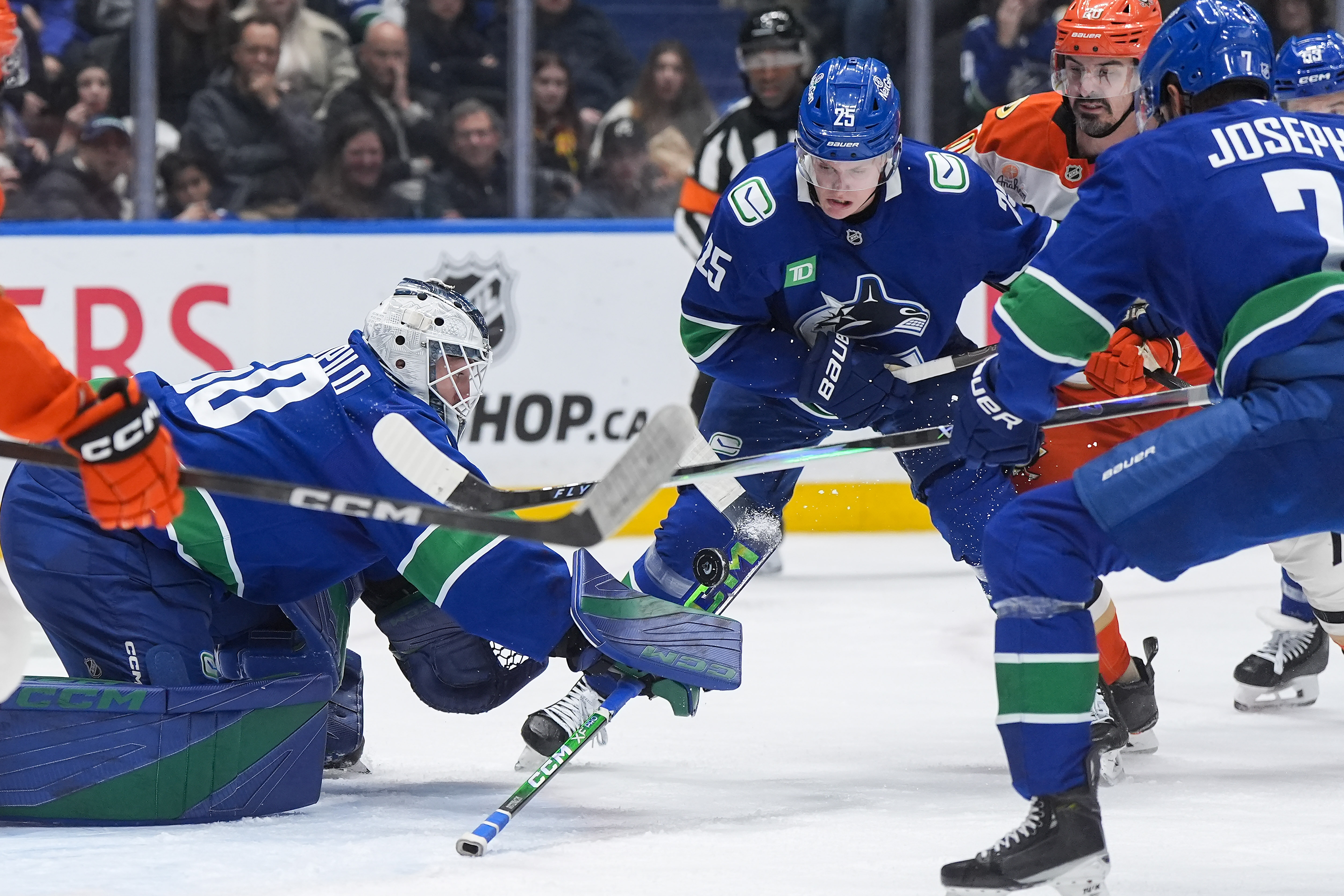 Vancouver Canucks goalie Nikita Tolopilo, left, makes a save as...