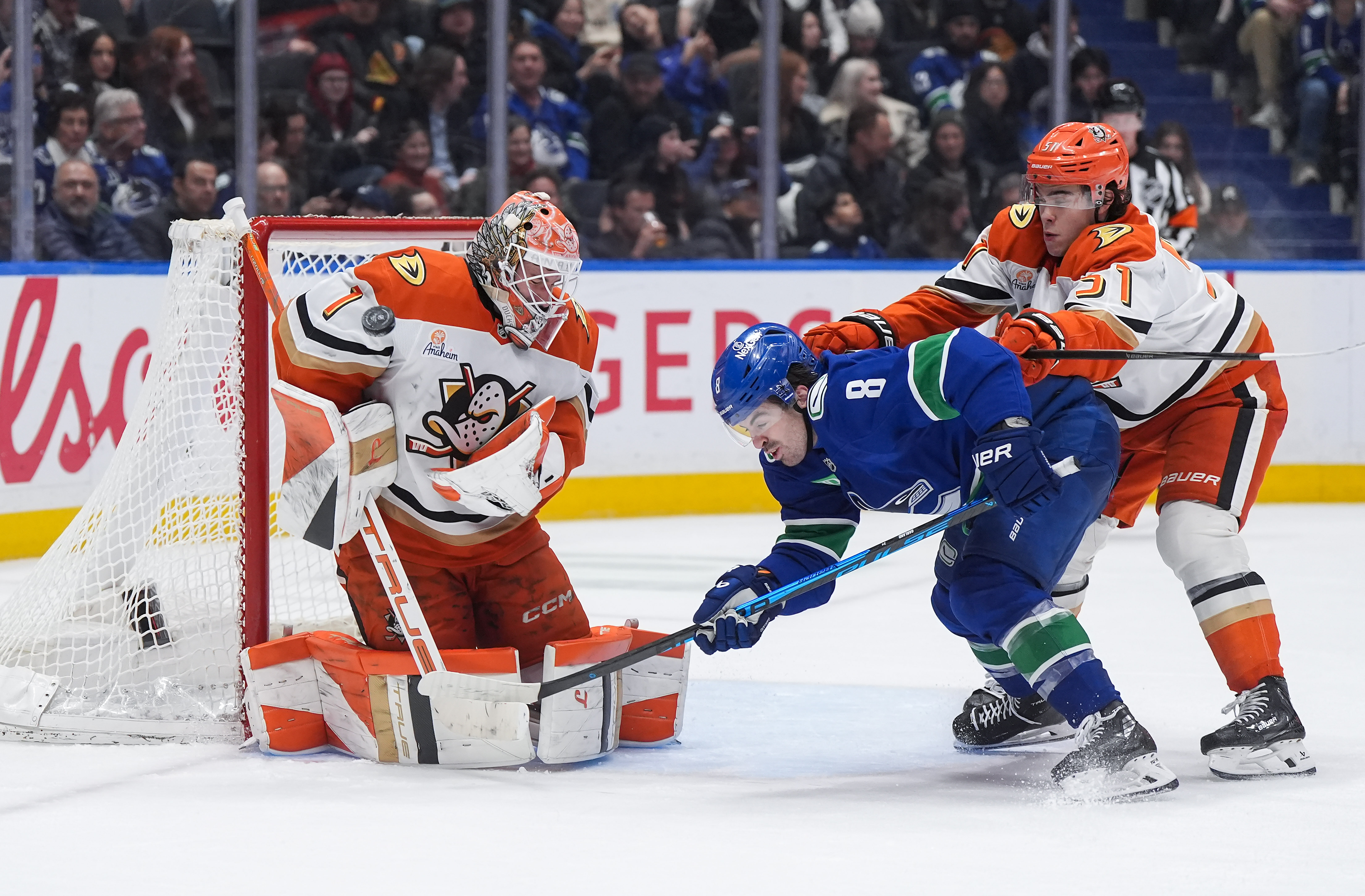 Ducks goaltender Lukas Dostal, left, makes the save as teammate...