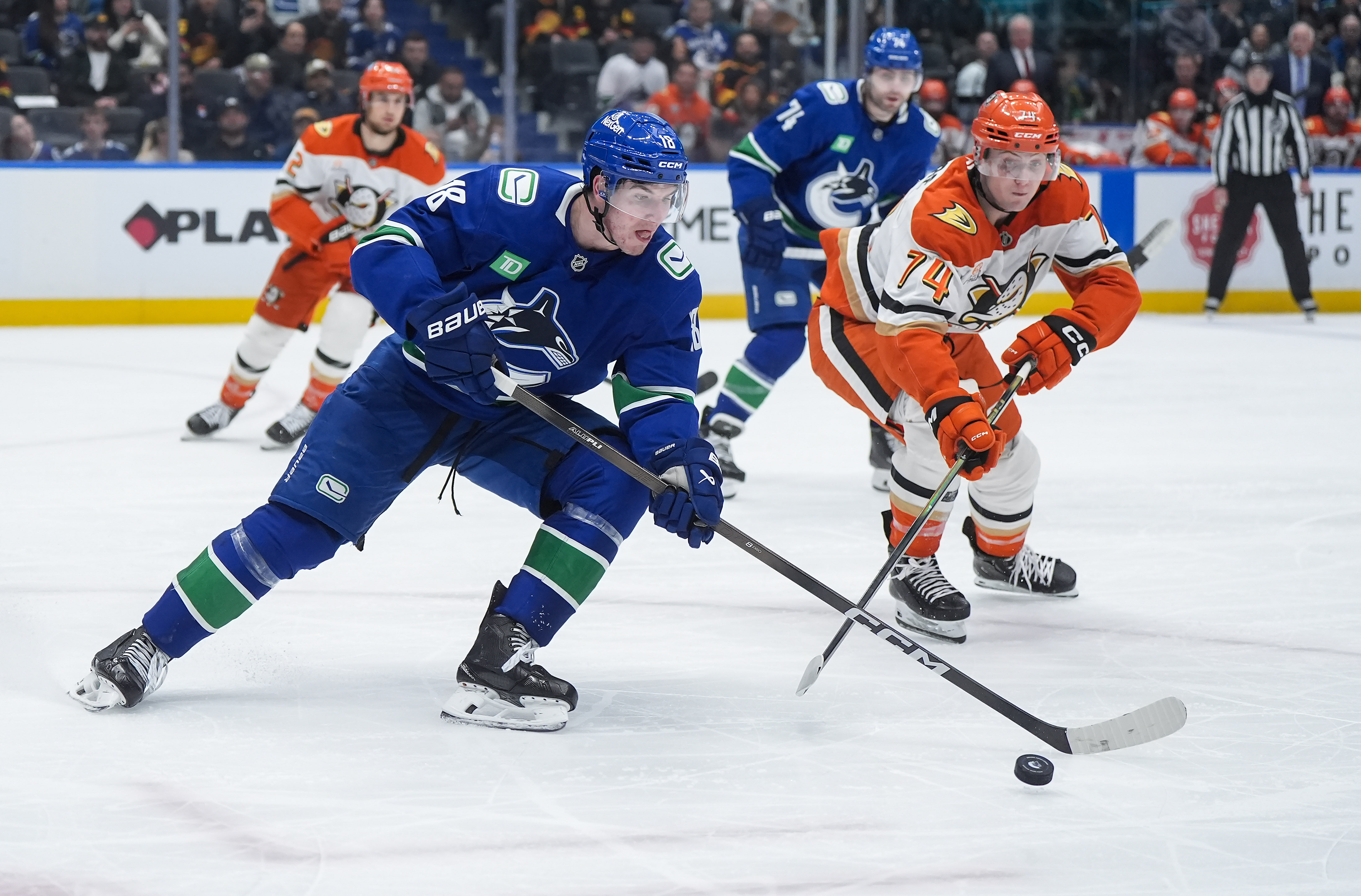 The Vancouver Canucks’ Drew O’Connor (18) skates with the puck...