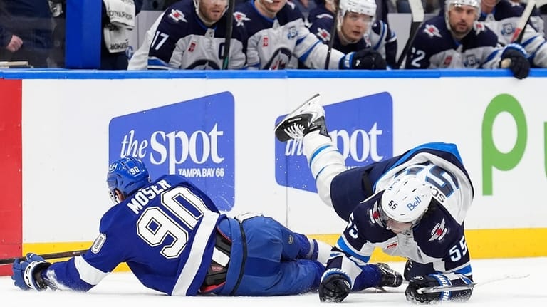 Winnipeg Jets center Mark Scheifele (55) trips over Tampa Bay...