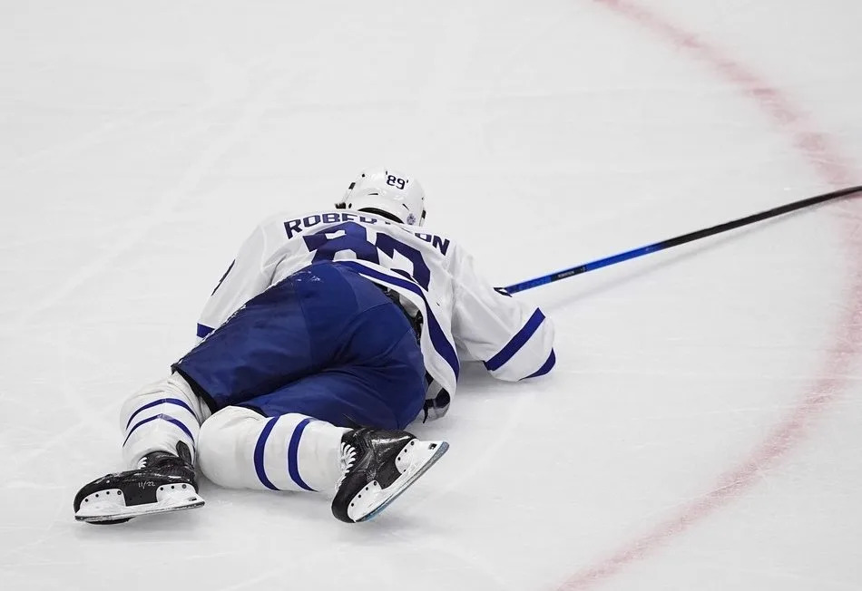 Toronto Maple Leafs left wing Nicholas Robertson lies on the ice after injuring his left leg in the first period of an NHL hockey game against the Colorado Avalanche, Monday, Jan. 12, 2026, in Denver.