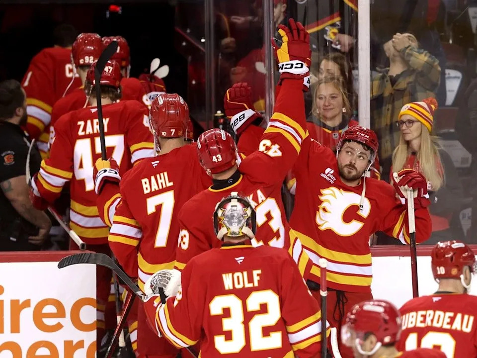 Rasmus Andersson (right) high-fives Flames teammates after Saturday’s win.