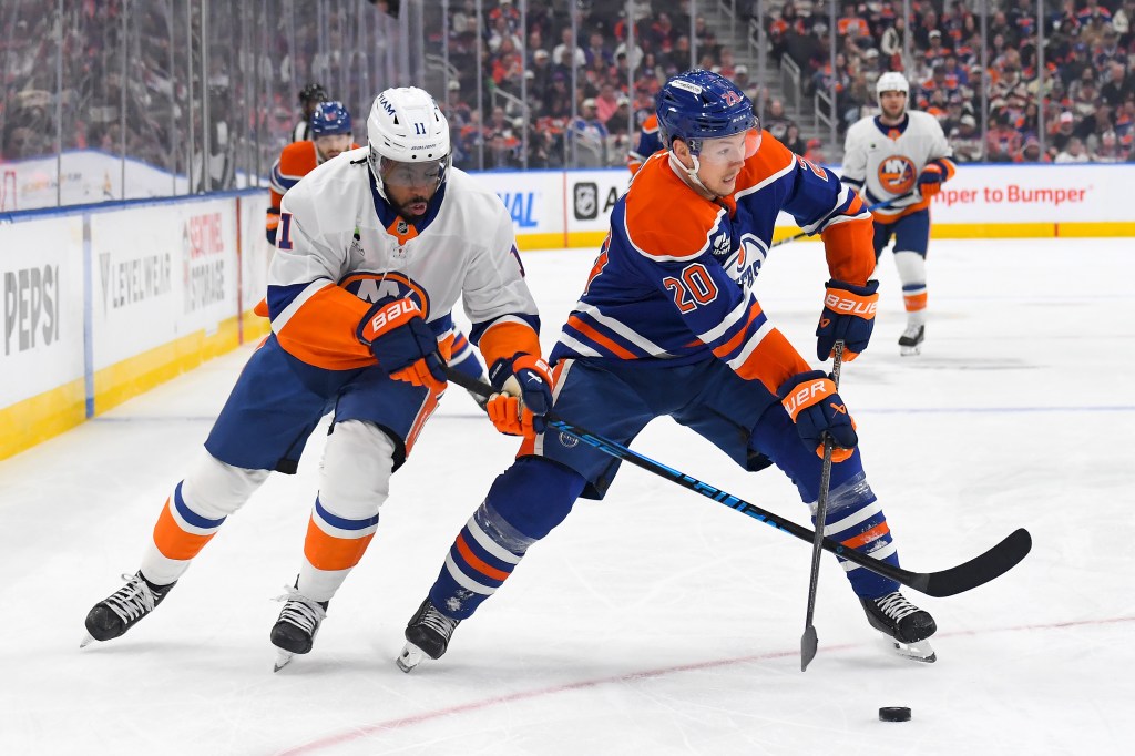 Curtis Lazar #20 of the Edmonton Oilers battles for the puck against Anthony Duclair #11 of the New York Islanders during the second period of the game at Rogers Place on January 15, 2026, in Edmonton, Alberta, Canada.
