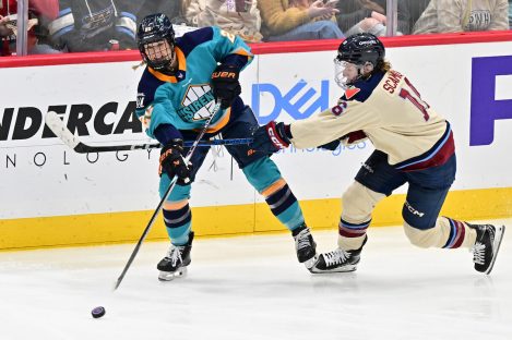WASHINGTON DC, JANUARY 18: Defender Allyson Simpson (20) of the New York Sirens passes the puck under pressure from Forward Hayley Scamurra (16) of the Montreal Victoire during the third period of the PWHL Takeover Tour game between the Montreal Victoire and New York Sirens on January 18, 2026 at Capital One Arena in Washington, DC. (Photo: Robert Raymer)