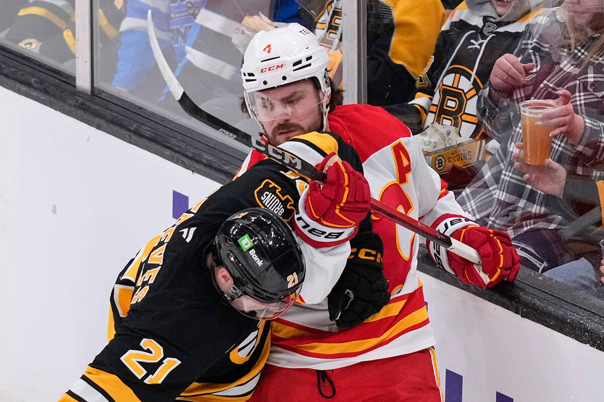 Calgary Flames defenseman Rasmus Andersson (4) tangles with Boston Bruins center Alex Steeves ( ...