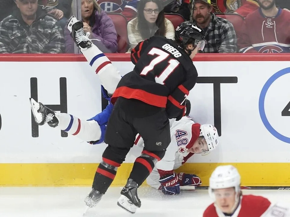  Canadiens defenceman Lane Hutson is checked into the boards by Senators forward Ridly Greig in the first period.