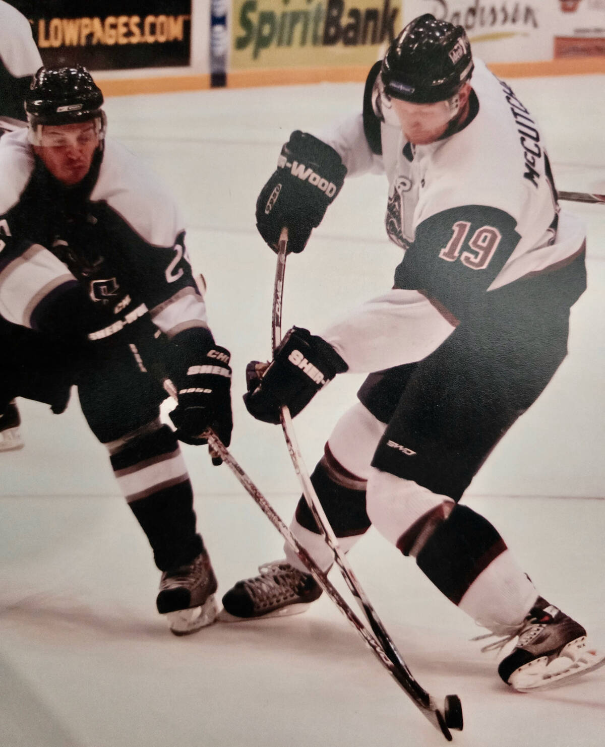 Warren McCutcheon's stick flexes as he's contacted by an opposing player during a hockey game.