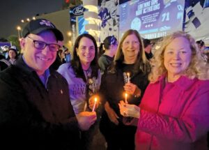 Steven Walk, Jill Neuman, Susan Kessler and Rochelle Walk share the flame from a single candle as they light their own during Jewish Heritage Night’s pre-game festivities.