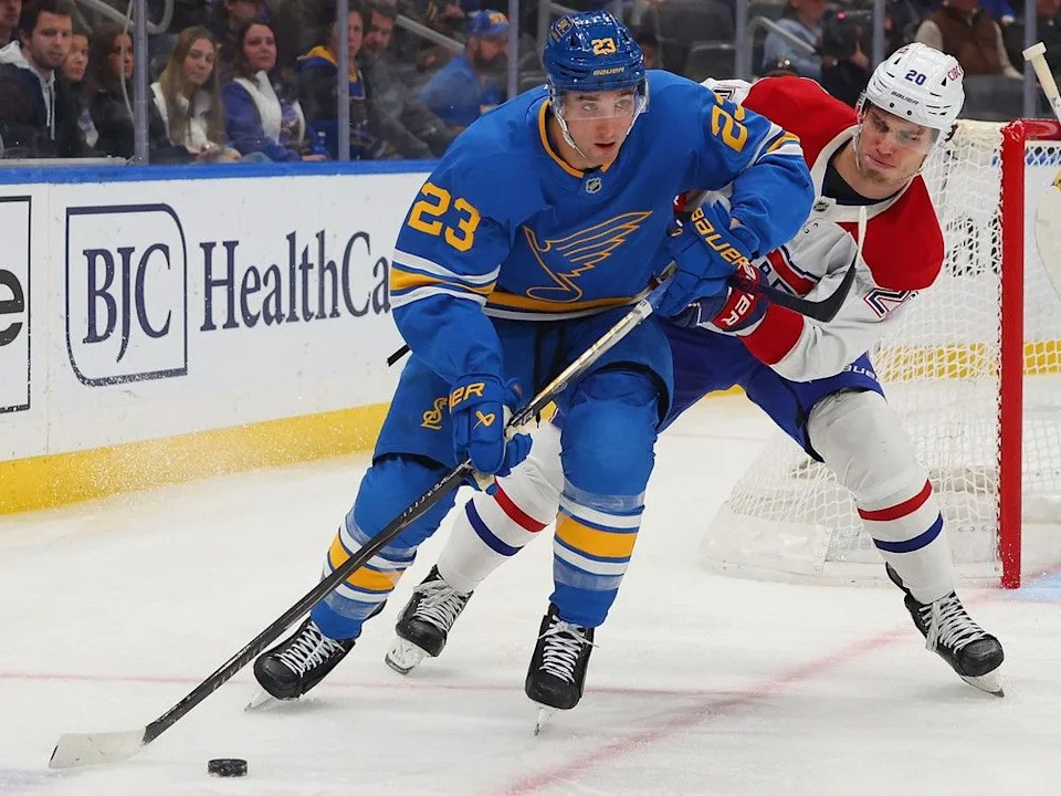  Blues’ Logan Mailloux (23) controls the puck against Canadiens’ Juraj Slafkovsky at Enterprise Center on Saturday, Jan. 3, 2026, in St. Louis.