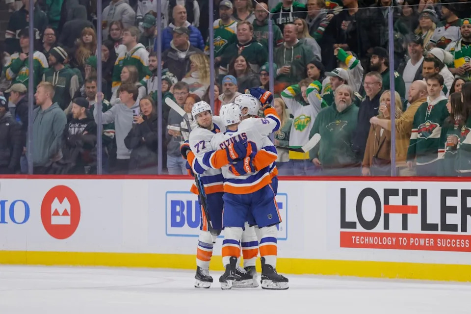 Simon Holmstrom (back right) celebrates with defenseman Tony DeAngelo and center Casey Cizikas after scoring during the game-winning overtime goal in the Islanders’ win over the Wild. AP
