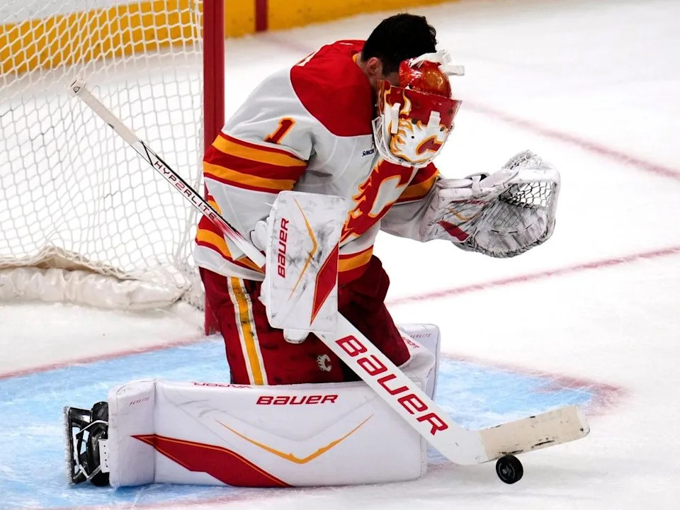  Flames goaltender Devin Cooley has his mask knocked off by a shot during Saturday’s game in Pittsburgh.