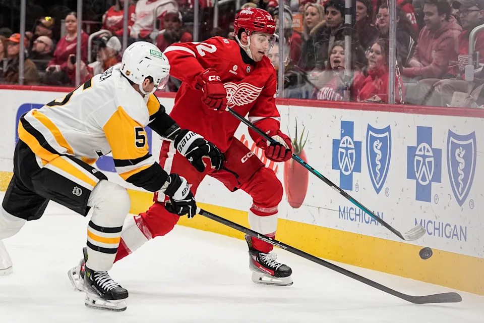 Detroit Red Wings center Marco Kasper (92) and Pittsburgh Penguins defenseman Ryan Shea (5) battle for the puck during the first period at Little Caesars Arena in Detroit on Saturday, Jan. 3, 2026.