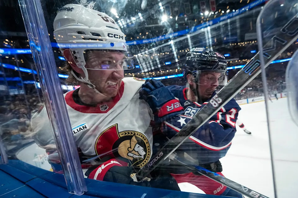Columbus Blue Jackets center Isac Lundestrom (21) hits Ottawa Senators defenseman Jake Sanderson (85) during the first period of the NHL hockey game at Nationwide Arena in Columbus on Dec. 11, 2025.