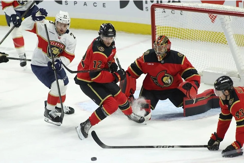 Carter Verhaeghe of the Panthers and the Senators’ Shane Pinto (12) and Tyler Kleven (43) watch the puck slide away in front of goaltender Leevi Merilainen in the first period.