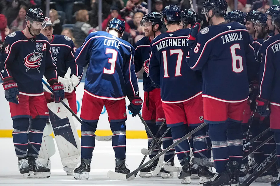 Teammates congratulate Blue Jackets center Charlie Coyle after a 1-0 win against the Stars that marked Coyle's 1,000th career NHL game.