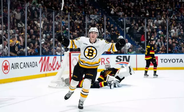 Boston Bruins' Fraser Minten (93) celebrates his game-winning goal against the Vancouver Canucks as Canucks goaltender Kevin Lankinen (32) lays on the ice and Tom Willander (5) skates away during overtime in an NHL hockey game in Vancouver, British Columbia, on Saturday, Jan. 3, 2026. (Ethan Cairns/The Canadian Press via AP)