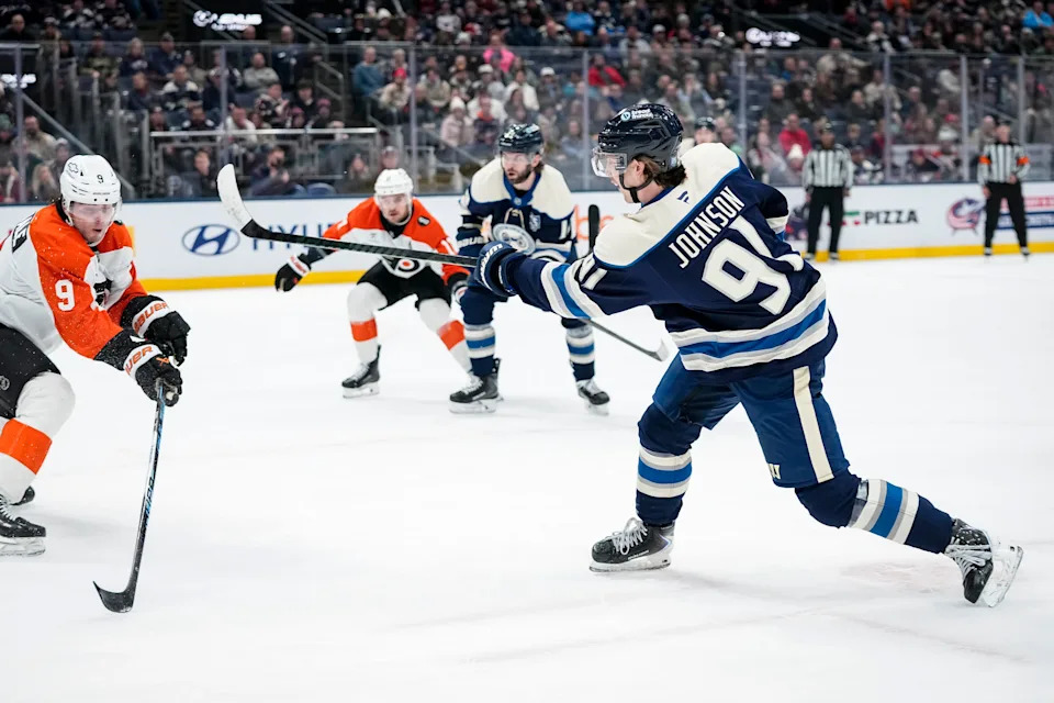 Columbus Blue Jackets center Kent Johnson (91) shoots past Philadelphia Flyers defenseman Jamie Drysdale (9) during the first period of the NHL hockey game at Nationwide Arena in Columbus on Jan. 28, 2026.