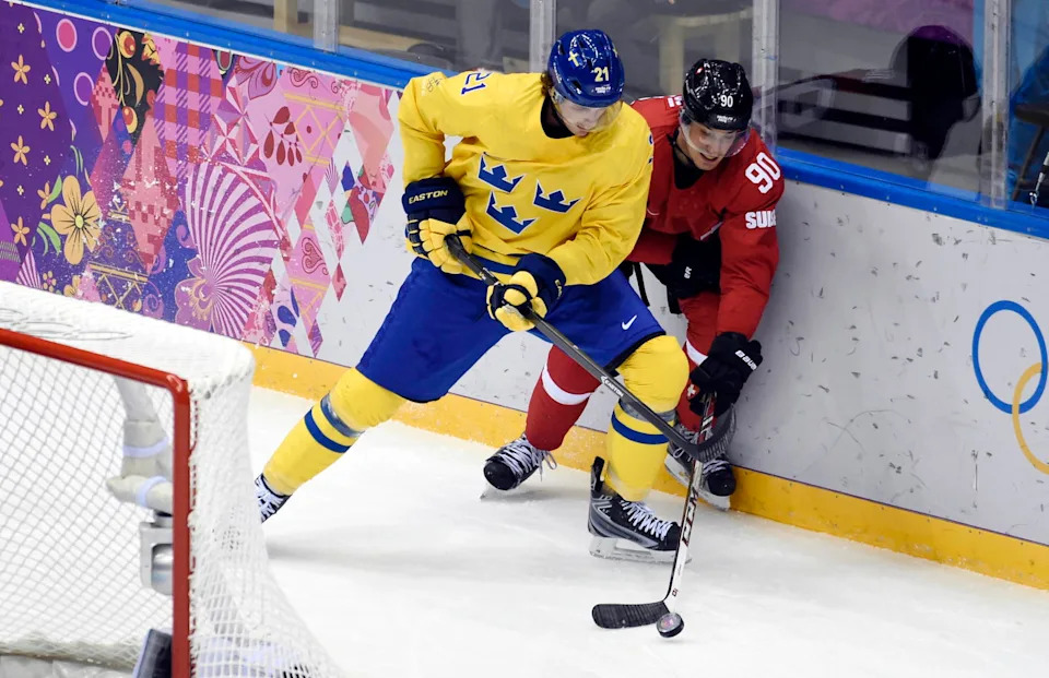Feb 14, 2014; Sochi, RUSSIA; Switzerland defenseman Roman Josi (90) battles for the puck with Sweden forward Loui Eriksson (21) in a men's preliminary round ice hockey game during the Sochi 2014 Olympic Winter Games at Bolshoy Ice Dome. Mandatory Credit: Scott Rovak-Imagn Images