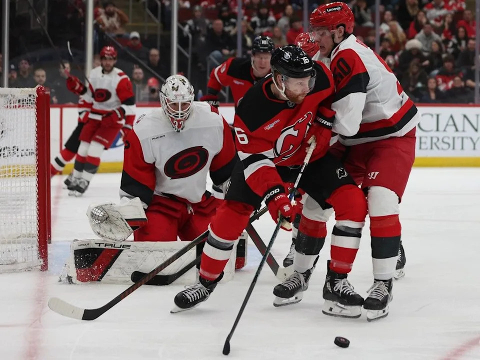  New Jersey Devils right wing Connor Brown (16) looks to pass the puck around Carolina Hurricanes left wing Eric Robinson (50) in the second period of an NHL hockey game, Sunday, Jan. 4, 2026, in Newark, N.J.