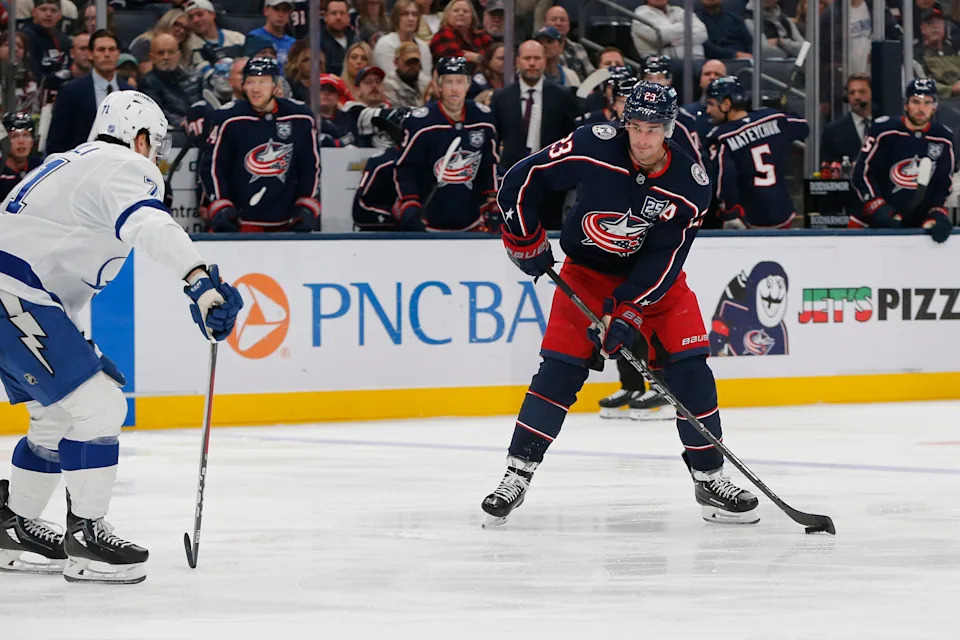 Oct 18, 2025; Columbus, Ohio, USA; Columbus Blue Jackets center Sean Monahan (23) looks to pass defended by Tampa Bay Lightning center Anthony Cirelli (71) during the second period at Nationwide Arena. Mandatory Credit: Russell LaBounty-Imagn Images